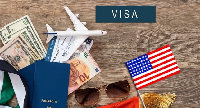 Flag of United States with passport and toy airplane on wooden background. Flight travel concept.