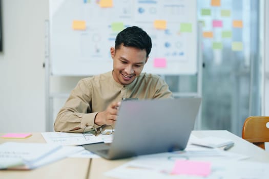 business owner or Asian male marketers are using business phones and computers to do office work.