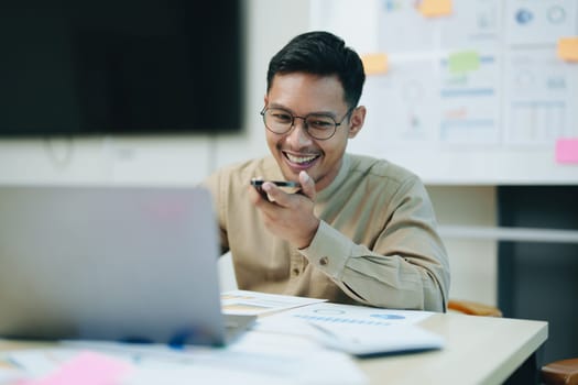 business owner or Asian male marketers are using business phones and computers to do office work.