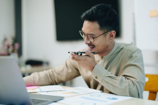 business owner or Asian male marketers are using business phones and computers to do office work.