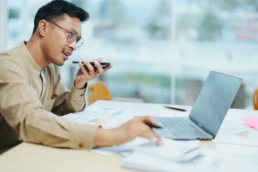 business owner or Asian male marketers are using business phones, calculator and computers to do office work.
