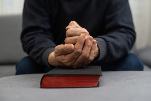 Man praying and reading Bible at home