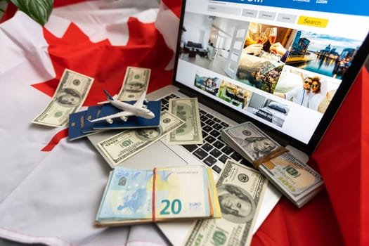 laptop with travel, money and canada flag.