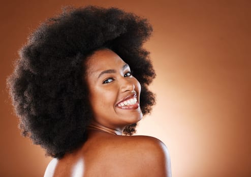 Beauty, skincare and a happy black woman with a smile and afro looking back on studio background. Health, wellness and youth, a woman with body care, healthy glowing skin and happy grooming lifestyle.