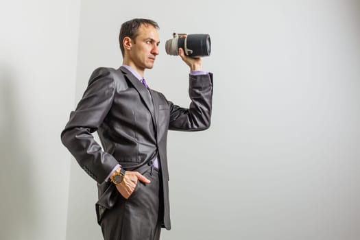 Businessman taking holding a lens on white background.
