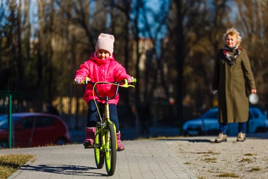 little girl riding bicycle in city park