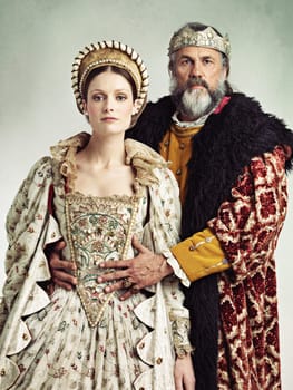 Costume, portrait and king and queen in crown isolated on studio background for medieval, renaissance and fashion history. Headshot of royal couple hug with power, wealth and vintage culture and love.