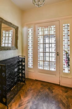 a living room with an antique dresser and large mirror on the wall in front of the door to the entryway