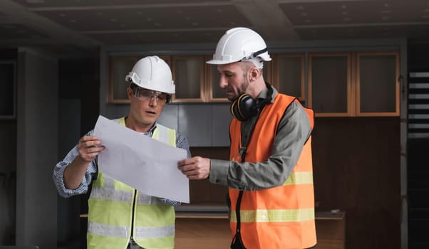 Civil engineer teams meeting working together wear worker helmets hardhat on construction site in modern city. Foreman industry project manager engineer teamwork. Asian industry professional team...