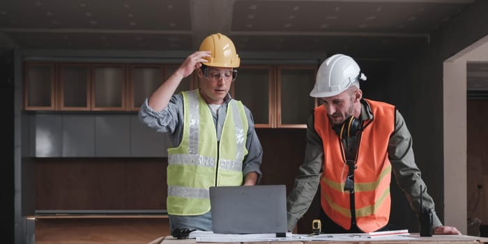 Civil engineer teams meeting working together wear worker helmets hardhat on construction site in modern city. Foreman industry project manager engineer teamwork. Asian industry professional team...