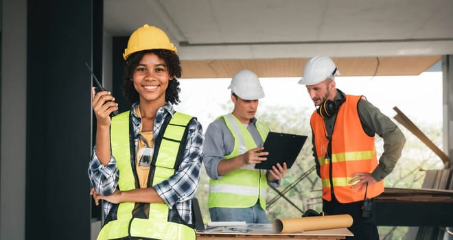 Leadership Concept by Female Engineers : Portrait of a happy female engineer in front of a group of male construction workers : Effective teamwork..