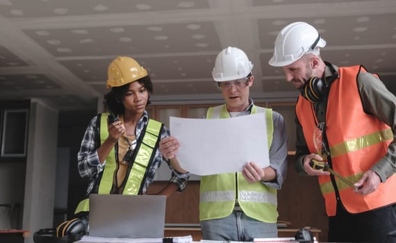 Civil engineer teams meeting working together wear worker helmets hardhat on construction site in modern city. Foreman industry project manager engineer teamwork. Asian industry professional team...