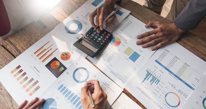 Business People Meeting using laptop computer,calculator,notebook,stock market chart paper for analysis Plans to improve quality next month. Conference Discussion Corporate Concept....