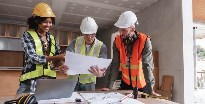 Civil engineer teams meeting working together wear worker helmets hardhat on construction site in modern city. Foreman industry project manager engineer teamwork. Asian industry professional team...