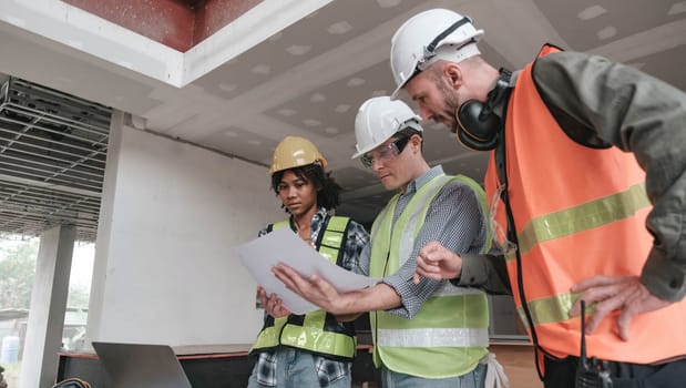 Civil engineer teams meeting working together wear worker helmets hardhat on construction site in modern city. Foreman industry project manager engineer teamwork. Asian industry professional team...