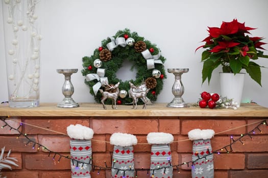 Decoration on the wooden shelf. Fireplace made of bricks and warm socks.