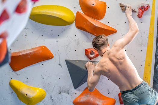 young man on a boulder climbing wall. High quality photo