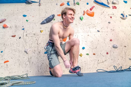 putting on climbing shoes next to the climbing wall. High quality photo