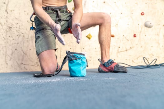 applying magnesium to the hands from the bag before climbing the climbing wall. High quality photo