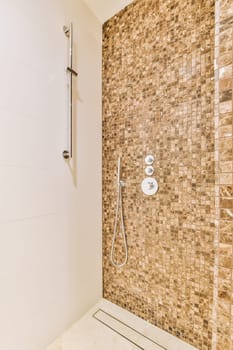 a bathroom with tile on the walls and shower head mounted to the wall in front of the bathtub is visible