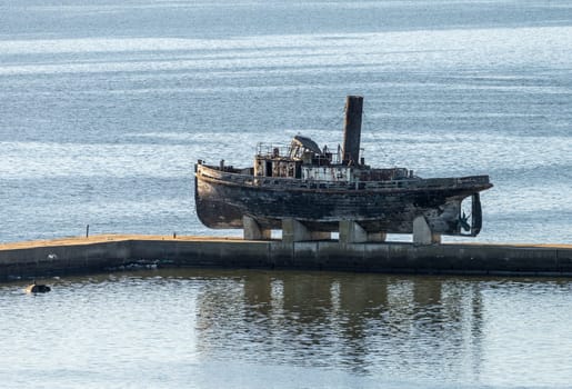 Abandoned wooden steam ship on stands on pier in Montevideo harbor in Uruguay
