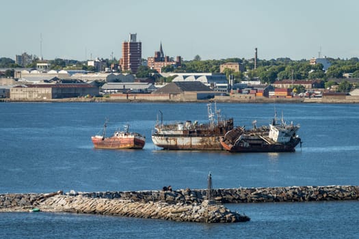 Montevideo, Uruguay - 5 February 2023:Abandoned ships rusting in shallow water in the harbor