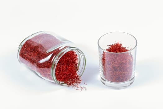 Many saffron threads in glass containers. Dry saffron in a glass dish. The spice is ready for use in cooking.