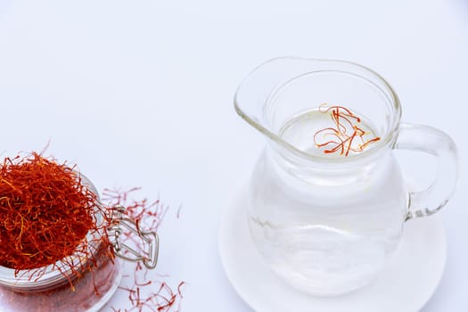 Dry saffron stamens are thrown into a decanter with water for infusion. Saffron drink.