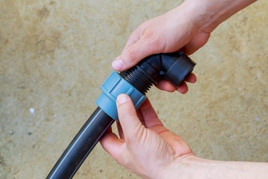 A plumber connects a polyethylene pipe using a special fitting for a polyethylene pipe.