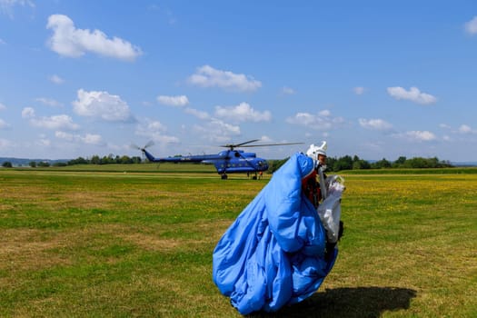 Skutech, Czech Republic, 31 July 2022: The parachutist goes to assemble the parachute after the jump. Sports entertainment in the sky.