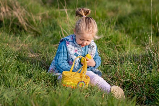Girl collects chocolate eggs in a basket for Easter