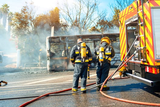 Rescue Team of Firefighters Arrive on the Car Crash fired passenger bus Traffic Accident Scene. Firemen fire department fight with fire on road. Accident disaster