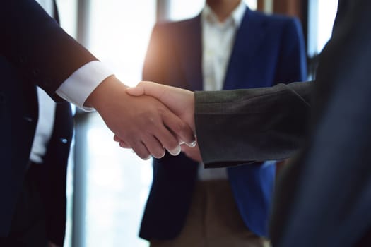 Asian entrepreneurs handshakes to congratulate the agreement between the two companies to enhance investment and financial strength. deal concept.