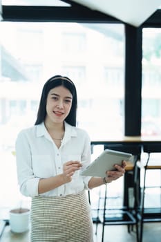 Portrait of a beautiful Asian teenage girl using a tablet computer.