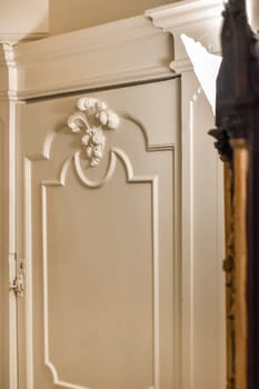 a white door with an ornate design on the front and side paneling around the doorway, which has been used for many years