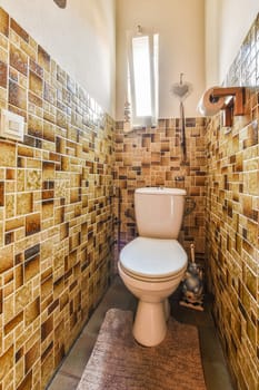 a tiled bathroom with a toilet in the middle and a rug on the floor next to the toilet is made out of tiles