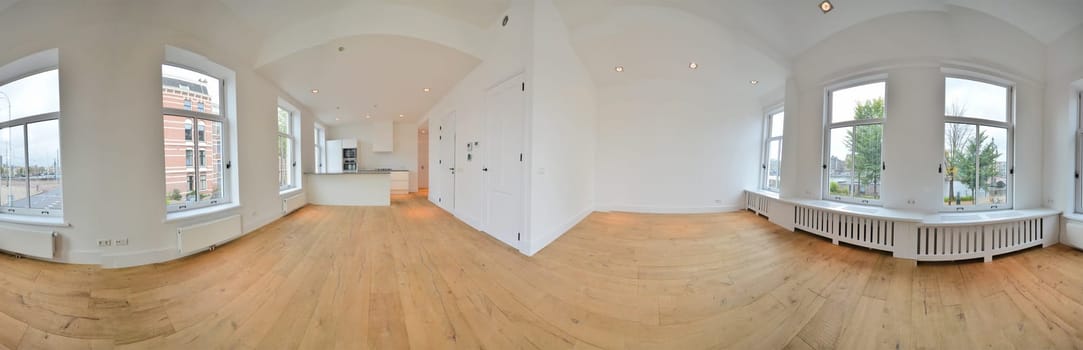 an empty living room with wood flooring and large windows looking out onto the street in front of the house