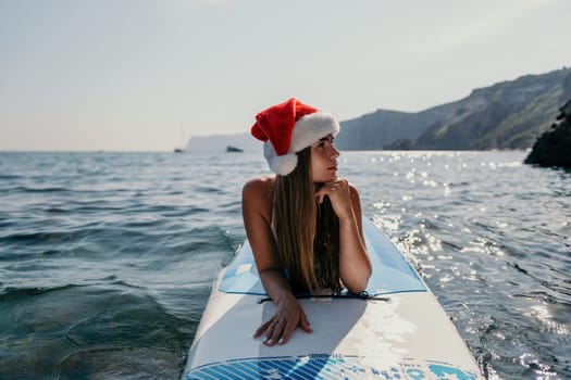 Close up shot of happy young caucasian woman looking at camera and smiling. Cute woman portrait in bikini posing on a volcanic rock high above the sea