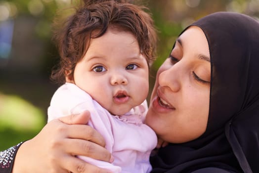 Shes a happy little one. a muslim mother and her little baby girl