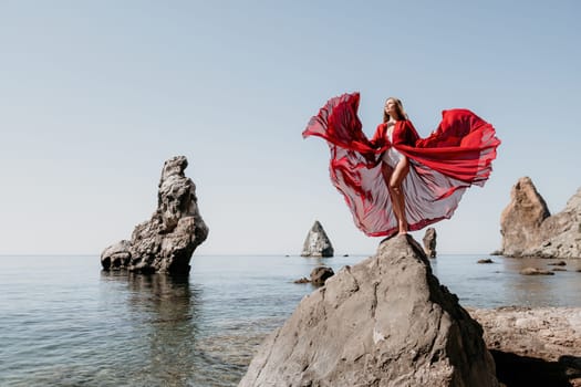 Woman travel sea. Happy tourist taking picture outdoors for memories. Woman traveler looks at the edge of the cliff on the sea bay of mountains, sharing travel adventure journey.