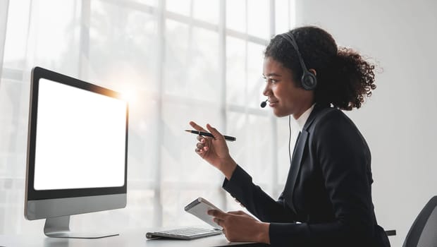 close up call center operator in wireless headset talking with customer, woman in headphones with microphone consulting client on phone in customer support service, looking at computer screen..