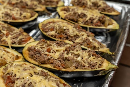 raw eggplant with meat on a baking sheet. Eggplant halves stuffed with minced meat, spices and cheese for baking in the oven. Delicious and healthy food