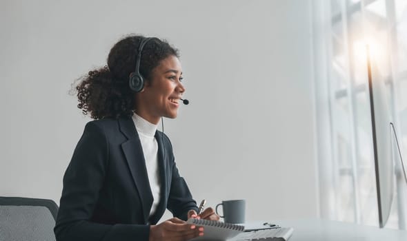 close up call center operator in wireless headset talking with customer, woman in headphones with microphone consulting client on phone in customer support service, looking at computer screen..