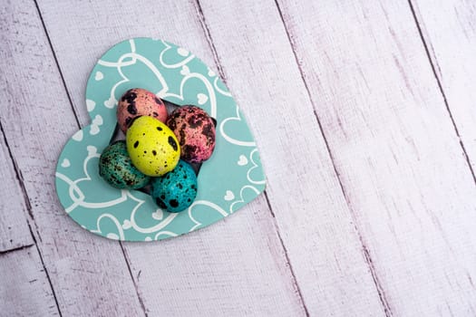 Colorful Easter eggs lie in a decorative Heart. Easter greeting card. Easter. Quail eggs. Spring holiday concept