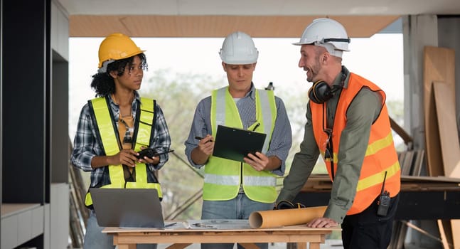 engineer team planning and discussing about construction building on table in working site.