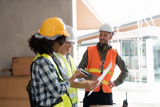 engineer team planning and discussing about construction building on table in working site.