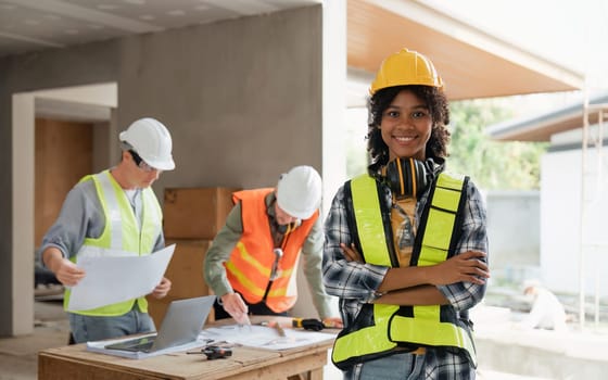 portrait female engineer project manager with construction gear and project blueprint Architecture team building plans.