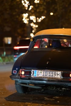 Backside of an old black Citroen DS classic car at night in Duesseldorf, Germany.