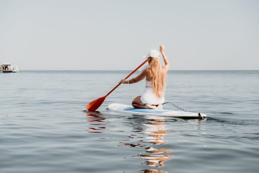 Close up shot of beautiful young caucasian woman with black hair and freckles looking at camera and smiling. Cute woman portrait in a pink bikini posing on a volcanic rock high above the sea