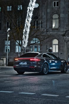 A black Porsche Panamera stands under an arc on Koenigsallee in Duesseldorf, Germany